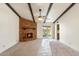 Spacious living room featuring a brick fireplace, exposed beam ceiling, and access to the backyard at 4312 W Paradise Dr, Glendale, AZ 85304