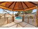 View of the backyard pool from a wooden gazebo with lattice details and a clear blue sky at 4312 W Paradise Dr, Glendale, AZ 85304