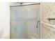 Bathroom shower featuring a frosted glass enclosure with white tile walls at 4312 W Paradise Dr, Glendale, AZ 85304