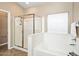 Bright bathroom with large tub, shower stall, and white tile surround at 44025 N 44Th Ln, New River, AZ 85087