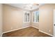 Light-filled bedroom includes wood floors, ceiling fan and two bright windows with coverings at 44025 N 44Th Ln, New River, AZ 85087