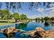 Beautiful lake view featuring mature trees, rocks, and a serene atmosphere, offering a peaceful outdoor experience at 44025 N 44Th Ln, New River, AZ 85087