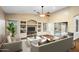 Living room with vaulted ceiling, ceiling fan, built-in shelving, and sliding glass doors to the backyard at 44025 N 44Th Ln, New River, AZ 85087