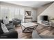 Cozy living room featuring wood floors, a modern coffee table, and large windows with plantation shutters at 4610 N 68Th St # 416, Scottsdale, AZ 85251