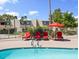 Community pool with red lounge chairs and umbrella, offering a relaxing outdoor space for residents at 4610 N 68Th St # 416, Scottsdale, AZ 85251