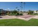 Community shuffleboard area with lush landscaping and tall palm trees at 4610 N 68Th St # 416, Scottsdale, AZ 85251