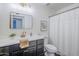 Bathroom with a framed mirror, single sink vanity, and a shower with a white curtain at 4814 E Pearce Rd, Phoenix, AZ 85044