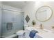 Bathroom featuring a marble vanity, round mirror and a glass-enclosed shower at 4814 E Pearce Rd, Phoenix, AZ 85044