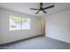 Bright bedroom with a large window, gray carpet and fresh white walls at 4814 E Pearce Rd, Phoenix, AZ 85044