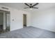 A spacious bedroom with a ceiling fan and neutral-colored carpet, featuring a walk-in closet at 4814 E Pearce Rd, Phoenix, AZ 85044