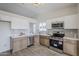 Modern kitchen with white upper cabinets, stainless steel appliances, and tile backsplash at 4814 E Pearce Rd, Phoenix, AZ 85044