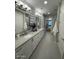 Bright bathroom featuring dual sinks, modern fixtures, and chevron-patterned accent wall at 5250 E Deer Valley Dr # 344, Phoenix, AZ 85054