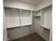 Walk-in closet featuring white shelving with metal rods for hanging clothes, and neutral carpeting at 5250 E Deer Valley Dr # 344, Phoenix, AZ 85054