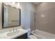 Modern bathroom features a sleek vanity, bathtub with tile surround, and a large mirror at 551 E Citrus Hollow Way, Queen Creek, AZ 85140