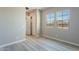 Bright bedroom with wood-look flooring, neutral walls, windows and an open closet at 551 E Citrus Hollow Way, Queen Creek, AZ 85140