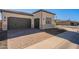 Exterior angle of a home showing a three car garage and a brick driveway at 551 E Citrus Hollow Way, Queen Creek, AZ 85140