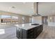 Open-concept kitchen featuring a central island with a cooktop and dark wooden cabinets beneath the white countertop at 551 E Citrus Hollow Way, Queen Creek, AZ 85140