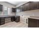 Functional laundry room with dark cabinetry, countertop, sink and window for a bright and efficient space at 551 E Citrus Hollow Way, Queen Creek, AZ 85140