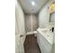 Modern bathroom with a tiled shower, white vanity, updated fixtures, and wood-look tile flooring at 5729 N 64Th Dr, Glendale, AZ 85301