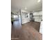 Bright kitchen featuring stainless steel appliances, white cabinetry, stone countertops, and wood-look tile flooring at 5729 N 64Th Dr, Glendale, AZ 85301