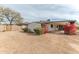 Backyard view of the home with a covered patio, mature trees, and desert landscaping, ideal for outdoor living at 5911 E Peak View E Rd, Cave Creek, AZ 85331