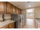 Practical laundry room with modern washer and dryer, storage cabinets, granite countertops, and a sink for convenience at 5911 E Peak View E Rd, Cave Creek, AZ 85331