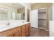 Bathroom featuring double sinks, tile flooring, and glass shower and walk-in closet access at 5948 W Leiber Pl, Glendale, AZ 85310