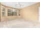 Spacious primary bedroom featuring a ceiling fan, neutral carpeting, and bright natural light at 5948 W Leiber Pl, Glendale, AZ 85310