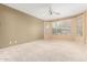 Light-filled primary bedroom featuring neutral carpet, ceiling fan, and corner windows at 5948 W Leiber Pl, Glendale, AZ 85310