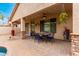 Inviting covered patio with a ceiling fan, outdoor lighting, and stone pillars at 5948 W Leiber Pl, Glendale, AZ 85310