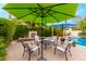 Cozy patio area features a fireplace, comfortable seating, and shade from a green umbrella at 5948 W Leiber Pl, Glendale, AZ 85310