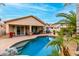 Relaxing backyard oasis with a pool, covered patio, and lush tropical landscaping at 5948 W Leiber Pl, Glendale, AZ 85310