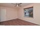 This bedroom features wood floors, a ceiling fan, and a window with wooden blinds at 655 W Mission Dr, Chandler, AZ 85225