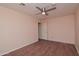 Bedroom with wood floors, ceiling fan, and a door leading to another room at 655 W Mission Dr, Chandler, AZ 85225