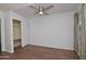 Bedroom with wood floors, ceiling fan, window, and a closet with sliding doors at 655 W Mission Dr, Chandler, AZ 85225