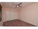 Bedroom with wood floors, a ceiling fan, and a closet with sliding doors at 655 W Mission Dr, Chandler, AZ 85225