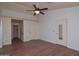 Main bedroom with hardwood floors, ceiling fan, and a doorway to an en suite bathroom at 655 W Mission Dr, Chandler, AZ 85225