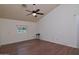 Main bedroom with hardwood floors, ceiling fan, and a large window overlooking the backyard at 655 W Mission Dr, Chandler, AZ 85225