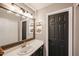 Bathroom featuring large mirror, vanity with solid surface counter, and a dark painted door at 853 E Ross Ave, Phoenix, AZ 85024