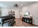 Bright living room features wood floors, a piano, a cabinet, and a view through to a connected room at 853 E Ross Ave, Phoenix, AZ 85024