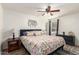 Cozy bedroom featuring a plush floral-patterned comforter, dark wood furnishings, and a ceiling fan at 870 S Palm Ln # 55, Chandler, AZ 85225