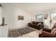 Comfortable living room with neutral tile floors, a leather sofa, and a large window providing natural light at 870 S Palm Ln # 55, Chandler, AZ 85225