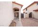 Exterior view of the front entrance with a security door, beige stucco, and adjacent gravel landscaping at 909 W San Mateo Ct, Gilbert, AZ 85233