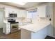 Bright kitchen featuring white cabinetry, stainless steel appliances, and updated countertops at 909 W San Mateo Ct, Gilbert, AZ 85233