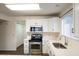 A well-lit kitchen featuring stainless steel appliances, white cabinets, countertops, and sleek hardware at 909 W San Mateo Ct, Gilbert, AZ 85233