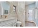 Well-lit bathroom with neutral tile, granite countertops, and glass-enclosed shower at 9160 E Wethersfield Rd, Scottsdale, AZ 85260