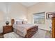 Comfortable bedroom featuring hardwood floors, a window view, and warm neutral paint at 9160 E Wethersfield Rd, Scottsdale, AZ 85260