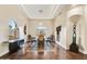 Elegant dining room with a tray ceiling, modern chandelier, and decorative art pieces at 9160 E Wethersfield Rd, Scottsdale, AZ 85260