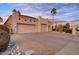 Spacious home exterior with a three car garage, desert landscaping, and neutral paint at 9160 E Wethersfield Rd, Scottsdale, AZ 85260