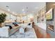 Inviting living room with a fireplace, built-in shelving, adjacent to kitchen with dark wood floors and lots of light at 9160 E Wethersfield Rd, Scottsdale, AZ 85260